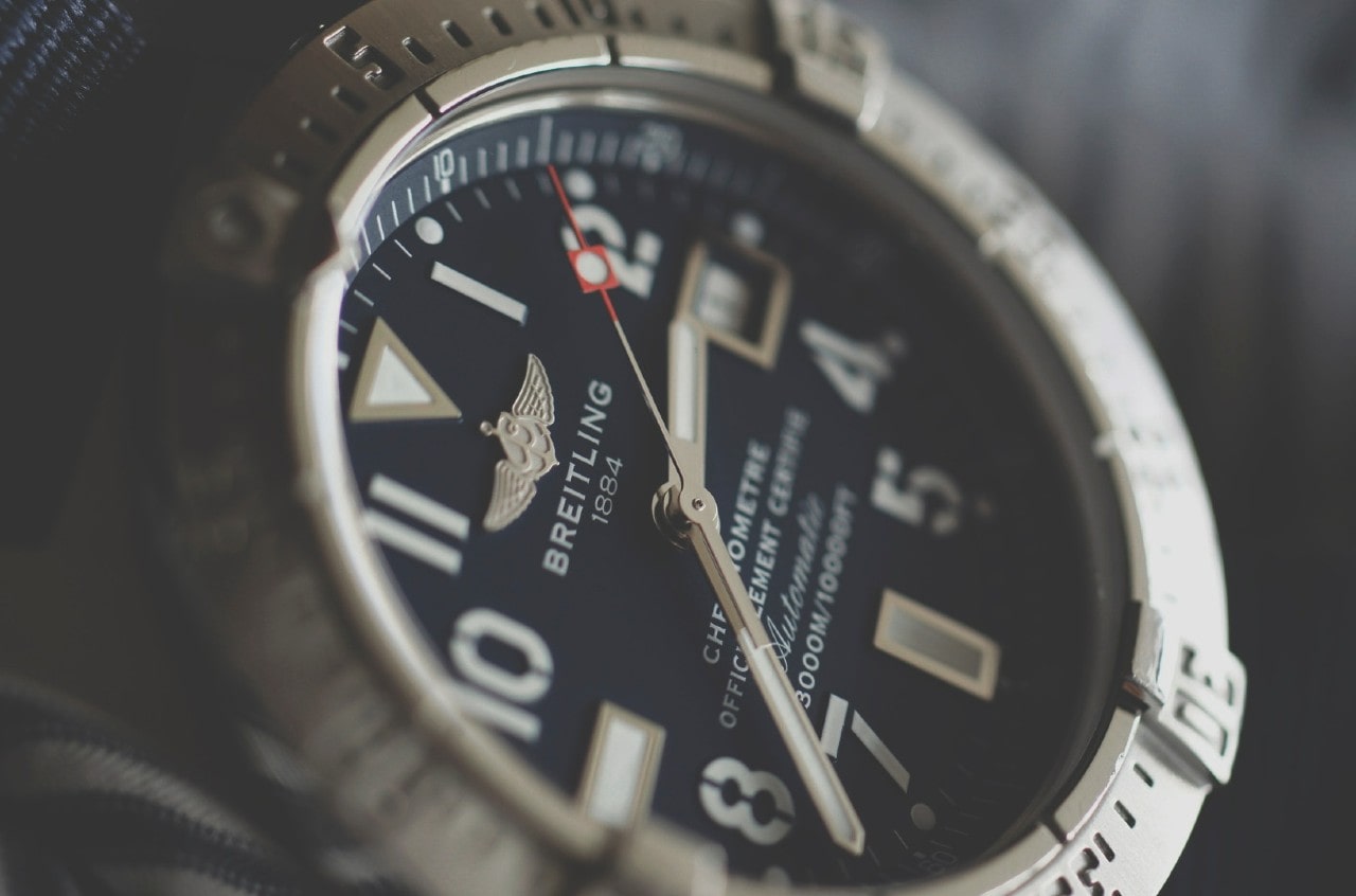 A close up of the dial of a Breitling watch face showing date complication along with stating its water resistance limit A close up of the dial of a Breitling watch face showing date complication along with stating its water resistance limit